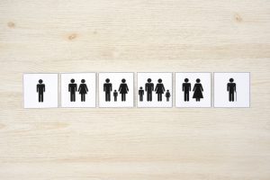 Black and white icons representing different family structures, including single individuals, couples, and families with children, illustrating the diverse relationship requirements for carer visa sponsorship.