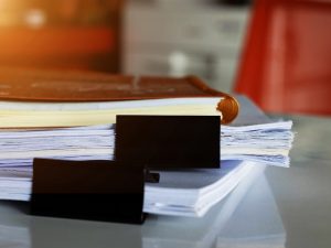 Stack of documents with paper clips, representing paperwork involved in the family migration to Australia and citizenship process.