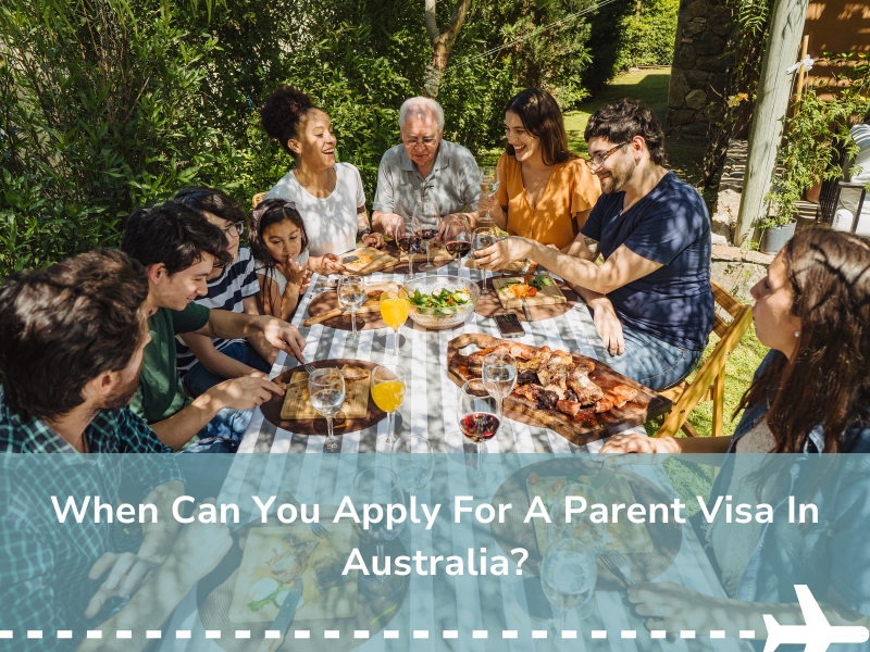 Family dining outdoors, discussing parent visa Australia application process, with diverse group enjoying a meal together.