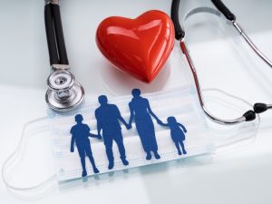 paper illustrating family holding hands with a heart indicating health insurance and life in australia for foreigners