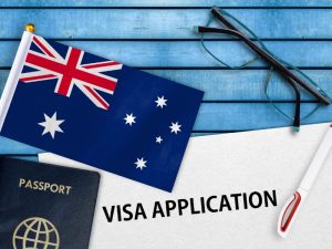 Child visa application with Australian flag, passport, and pen on a table.