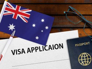 An Australian Visitor Visa Extension application form, pen, and passport on a desk, symbolising travel and visa processes.