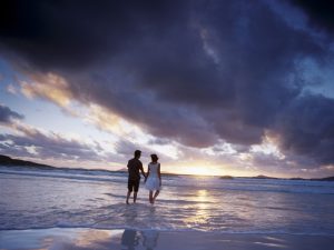 Couple enjoying a beach walk, illustrating a strong relationship for a relationship statement partner visa